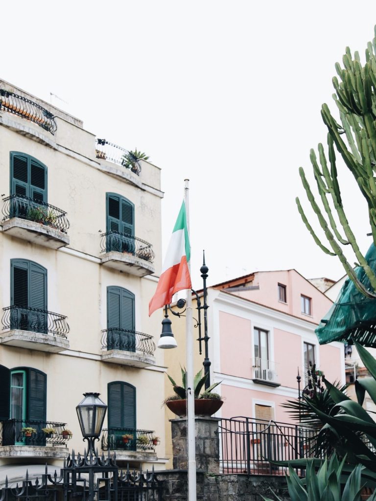Italian flag pole in Piazza Tasso -Sorrento, Italy. With city homes in the background
